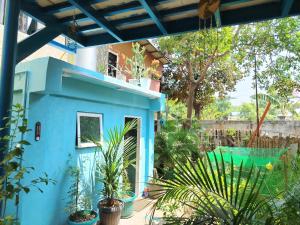 a blue house with plants in a yard at Blu Corner in Lian