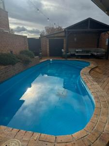 a large blue swimming pool in a yard at Clock Tower Motor Inn in Coonabarabran