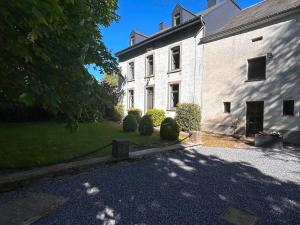 a large white building with bushes in front of it at Le Clos des Marronniers in Léglise