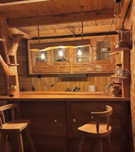 a kitchen with wooden cabinets and two stools at JUSA ჯუსა in Kantauri