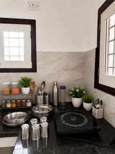 a kitchen with a counter top with pots and pans at SV Serenity Homestays in Gachibowli