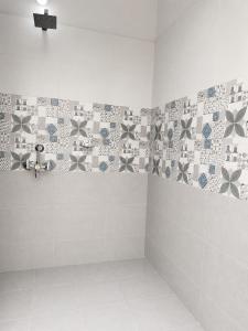 a bathroom with a shower with tiles on the wall at SV Serenity Homestays in Gachibowli +2 photos