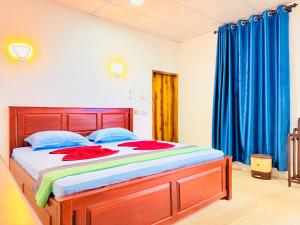 a bedroom with a large bed with blue curtains at Another World in Arugam Bay