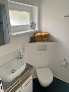 a bathroom with a sink and a toilet and a mirror at Häuschen mit Gartenblick in Idstein