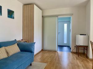 a living room with a blue couch and a door at Häuschen mit Gartenblick in Idstein