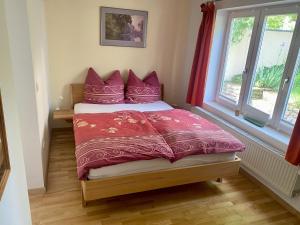 a bedroom with a bed with pink pillows and a window at Häuschen mit Gartenblick in Idstein