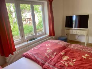 a bedroom with a bed and a tv and a window at Häuschen mit Gartenblick in Idstein