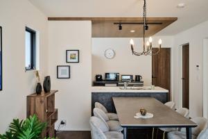 a kitchen and living room with a table and chairs at Black Grove House in Ginowan