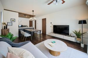 a living room with a couch and a table at Black Grove House in Ginowan