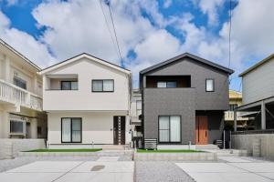two houses in front of a building at Black Grove House in Ginowan