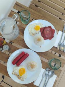 two plates of eggs and sausage on a table at Blu Corner in Lian +16 photos