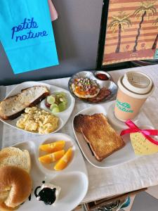 a table with a plate of breakfast foods and a cup of coffee at Halo Bonjour Perch in Ban Chuang +3 photos