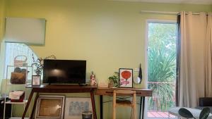 a living room with a flat screen tv on a table at Halo Bonjour Perch in Ban Chuang