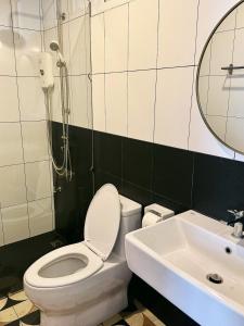 a bathroom with a toilet and a sink and a mirror at Halo Bonjour Perch in Ban Chuang
