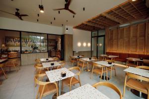 a restaurant with tables and chairs and a bar at The Melody Phuket Kata Beach in Kata Beach