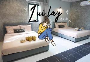 a room with two beds with a person sitting on the bed at Matchoon Homestay in Ban Noen Klang