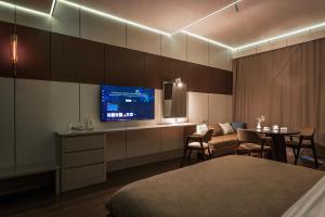 a hotel room with a bed and a tv and a table at Central one new apartments - panoramic skyline & boulevard in Tashkent