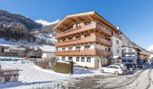 um grande edifício com carros estacionados na neve em Haus Fidelis Riml em Sölden