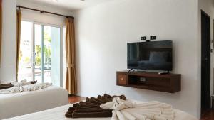 a living room with a tv and a bed at See Through Resort Haad Yao in Haad Yao