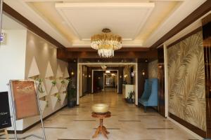 a hallway in a hotel with a chandelier at Sona Pristine Hotel And Resort Ambala in Dhūlkot