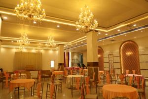 a banquet hall with tables and chairs and chandeliers at Sona Pristine Hotel And Resort Ambala in Dhūlkot +32 photos