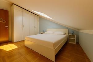 a bedroom with a white bed and a staircase at Apartment Andrea in Mirce