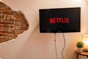 a television on a wall with the netflix sign on it at Apartment between Pisa Lucca and Florence in Cascina