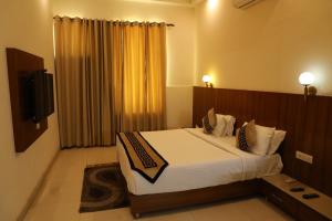 a bedroom with a large bed and a television at Sona Pristine Hotel And Resort Ambala in Dhūlkot
