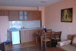 a kitchen and dining room with a table and cabinets at Condo Hotel Valentina in Obzor