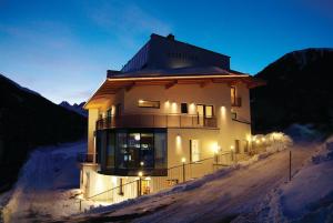 a building on a snow covered hill with lights at Astellina hotel-apart in Ischgl