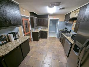 a large kitchen with black cabinets and a tile floor at Fresh start small breakfast cook and serve your self in Lubbock