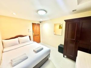 a bedroom with a bed and a wooden cabinet at P ratunam Residence Hotel in Bangkok