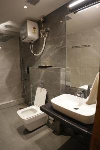 a bathroom with a toilet and a sink at Trevon Twin Tree Inn in Dhanbād