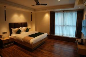 a bedroom with a bed and a ceiling fan at Trevon Twin Tree Inn in Dhanbād