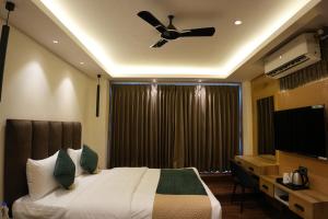 a bedroom with a bed and a ceiling fan at Trevon Twin Tree Inn in Dhanbād