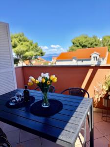 a blue table with a vase of flowers on a balcony at Apartment Andrea in Mirce