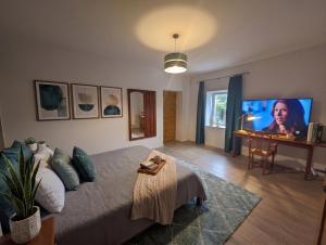 a living room with a large bed and a desk at Templomdomb Apartmanház in Tapolca