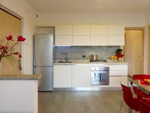 a kitchen with white cabinets and a stainless steel refrigerator at Casa Barbarossa in Colico