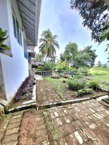 a brick walkway next to a house at Palm Cozy Villa 4 in Pasauran +10 photos