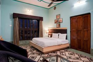 a bedroom with a bed and a couch in a room at Palette by CheckIn Heritage Scindia Ghat in Varanasi