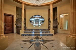 a lobby with stairs and a chandelier and a window at Willa Warmińska in Dywity