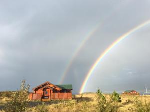 a double rainbow over a house in a field at Vacation Home Fagravik in Akureyri