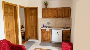 a kitchen with wooden cabinets and a white refrigerator at Happy 2Bedroom Apartments in Gornji Karin