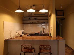 a kitchen with two chairs and a counter with two lights at Smile Home in Hanoi
