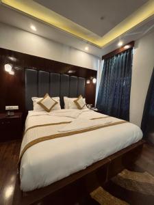a bedroom with a large bed with a large headboard at The Grand K2 Hotel in Leh +17 photos