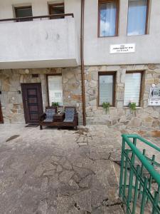 a stone building with two benches in front of it at Студио Анастасия in Smolyan