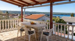 a patio with a table and chairs on a balcony at Happy 2Bedroom Apartments in Gornji Karin