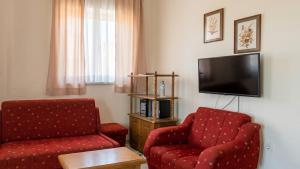 a living room with two chairs and a flat screen tv at Happy 2Bedroom Apartments in Gornji Karin