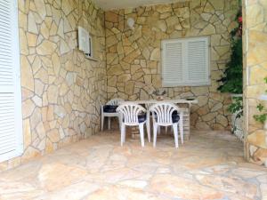 a patio with two chairs and a table in a stone wall at Happy 2Bedroom Apartments in Gornji Karin +23 photos