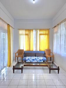 a living room with a blue couch in front of windows at Palm Cozy Villa 4 in Pasauran
